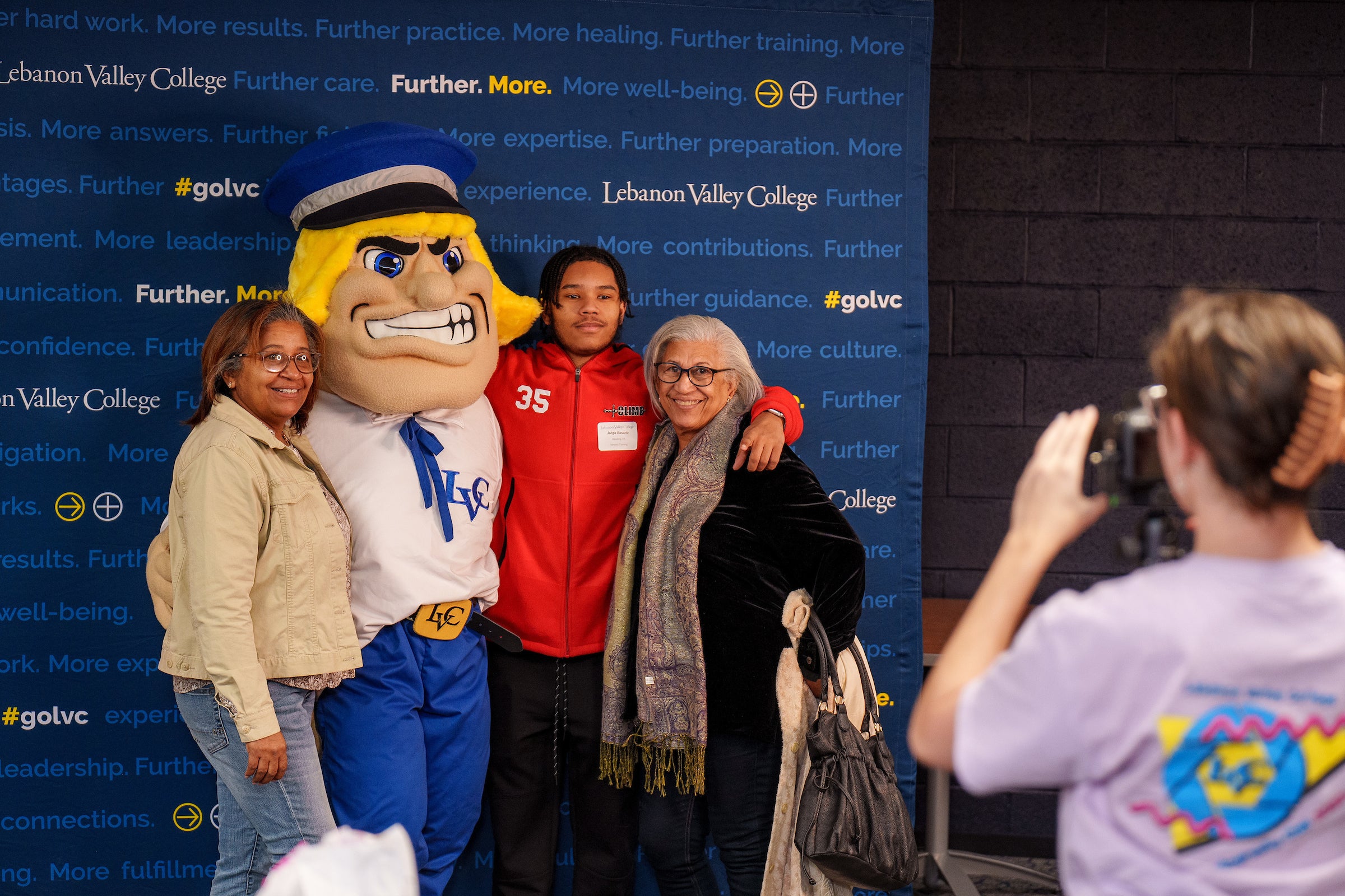 Student poses with family and the Dutchman mascot during event