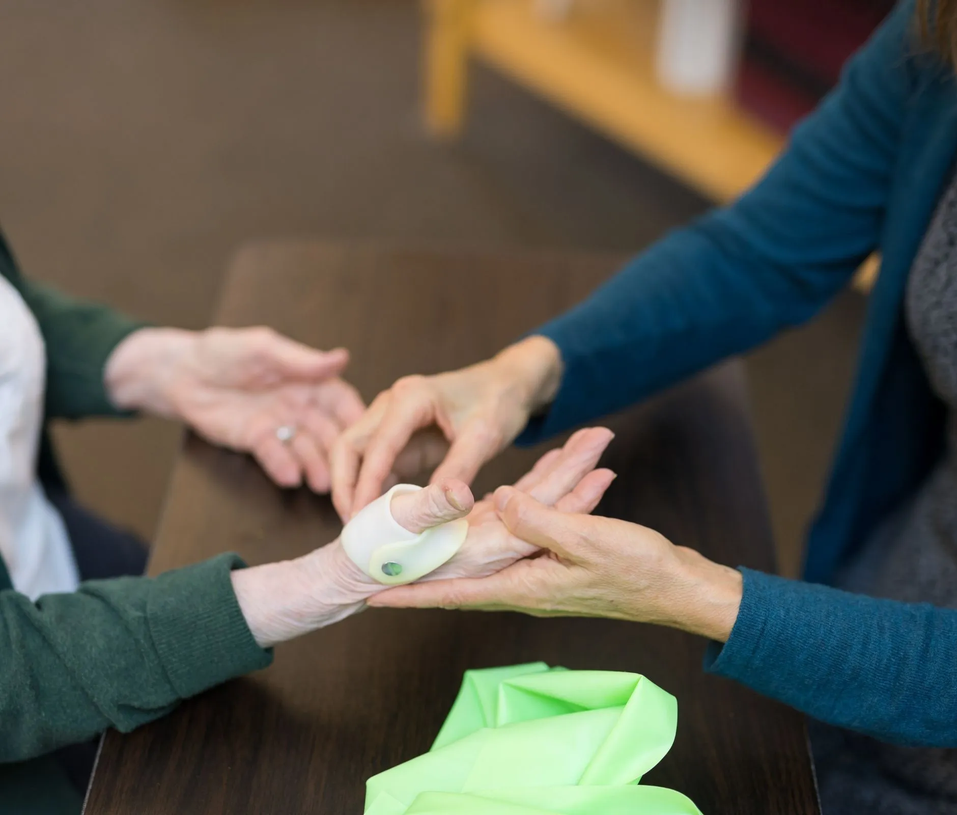 Occupational therapist works with elderly patient on hand strengthening exercises