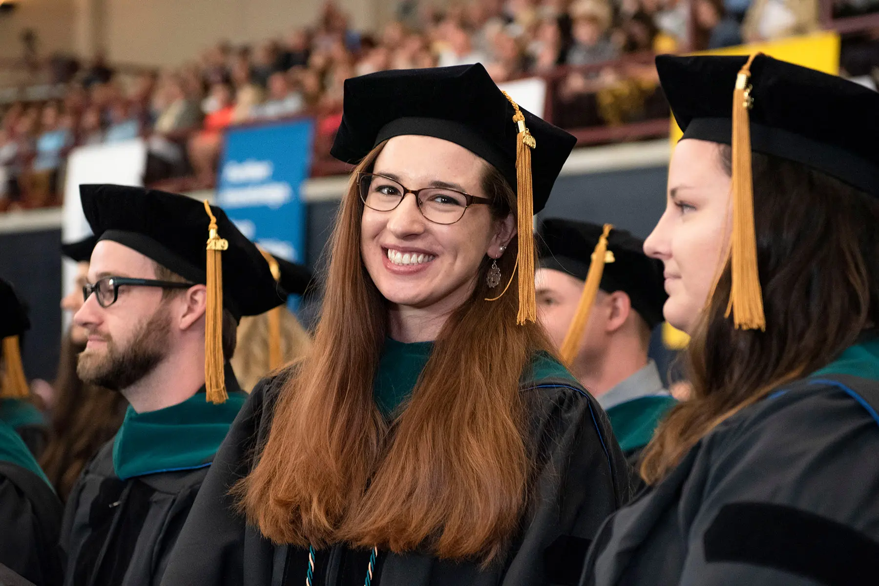 Woman smiling in graduate cap and gown.