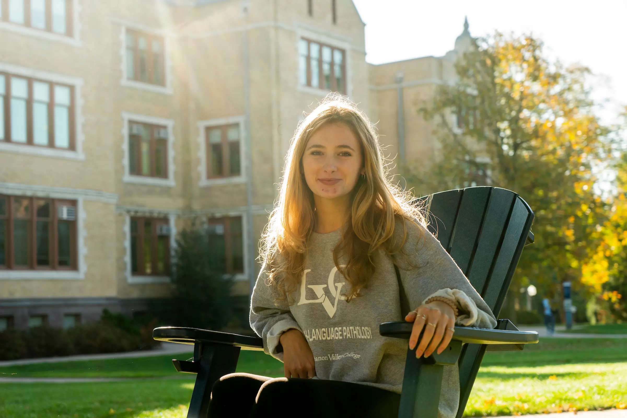 Morgan Landis sits in Adirondack chair on LVC quad