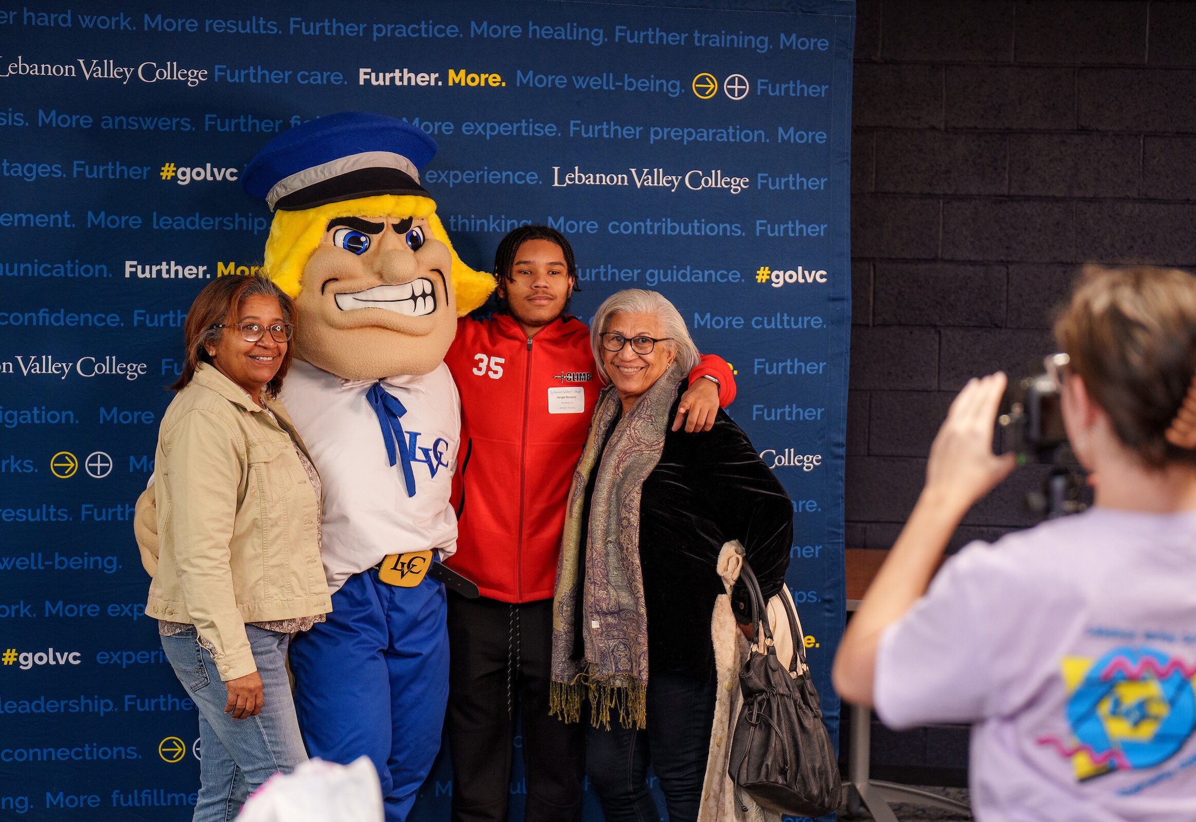 LVC accepted student poses with family and Dutchman mascot during event