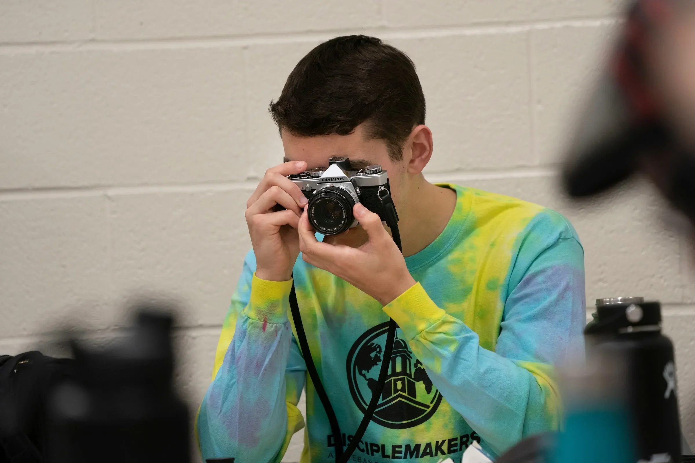 Student holds up camera during dark room class