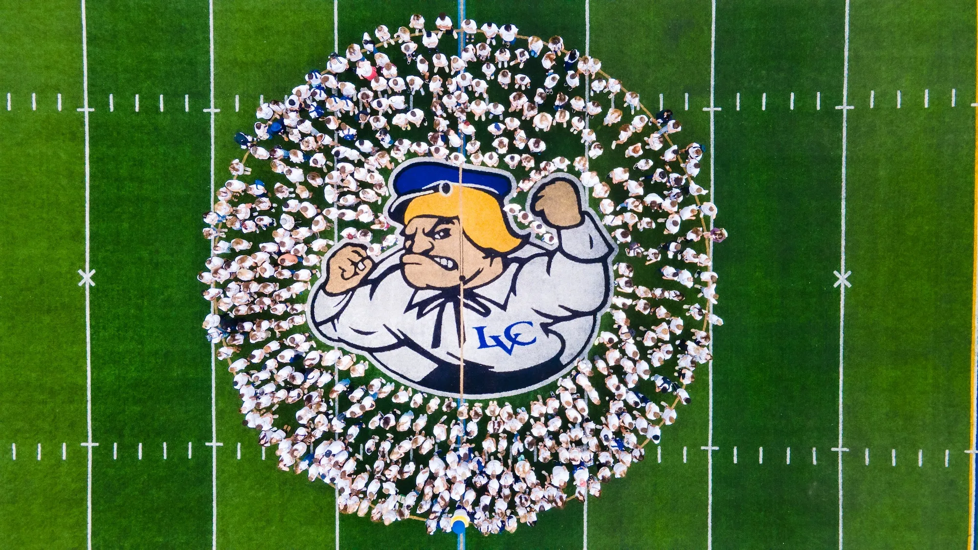 New LVC students pose around Dutchman logo on football field during New Student Orientation