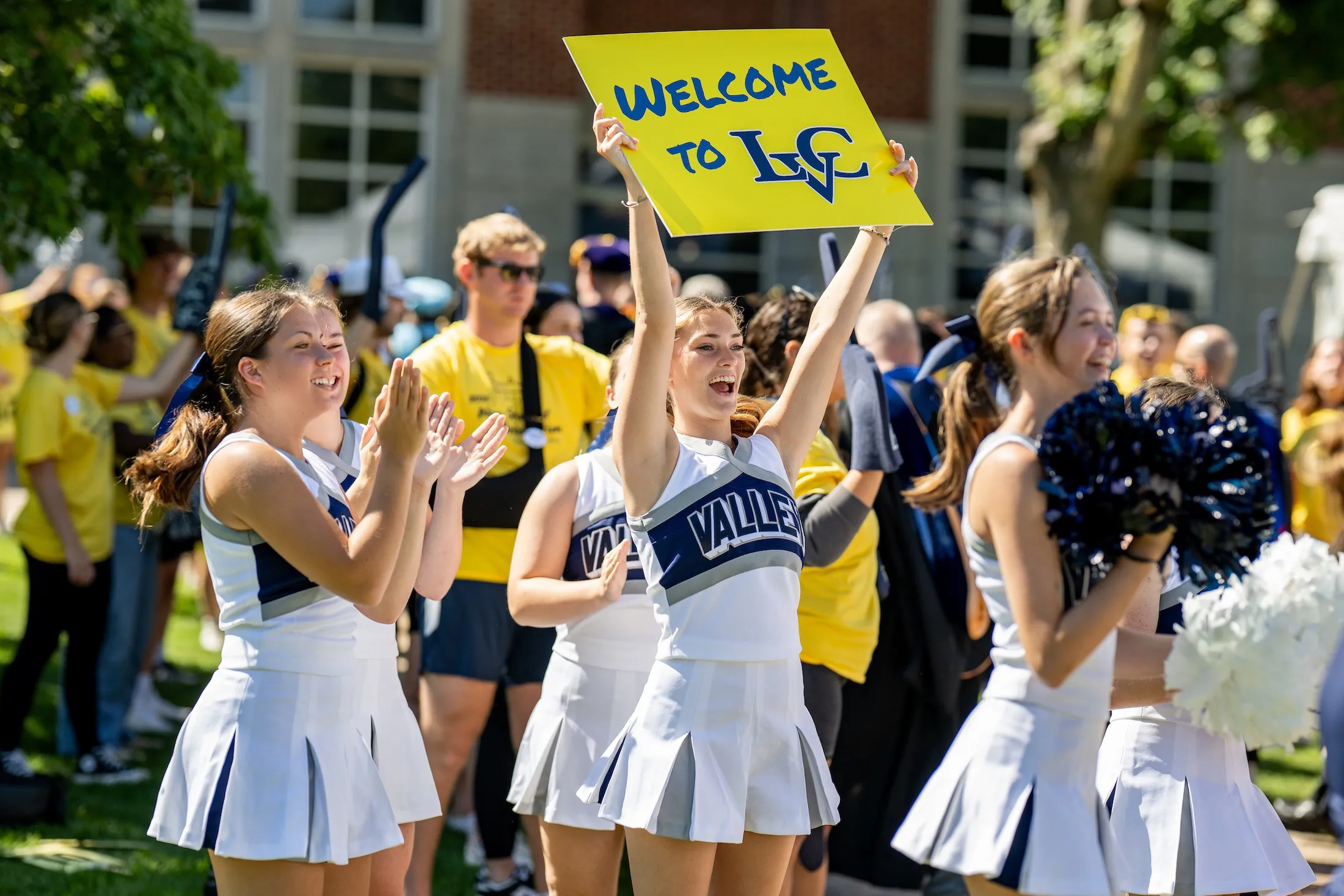 LVC cheerleader holds "Welcome to LVC" sign at orientation event