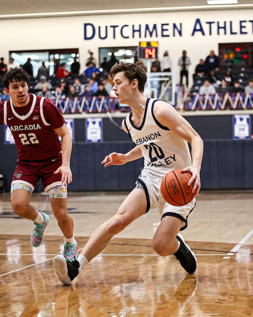LVC men's basketball player dribbles ball on court