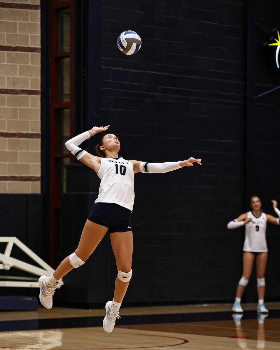 LVC women's volleyball player serves ball