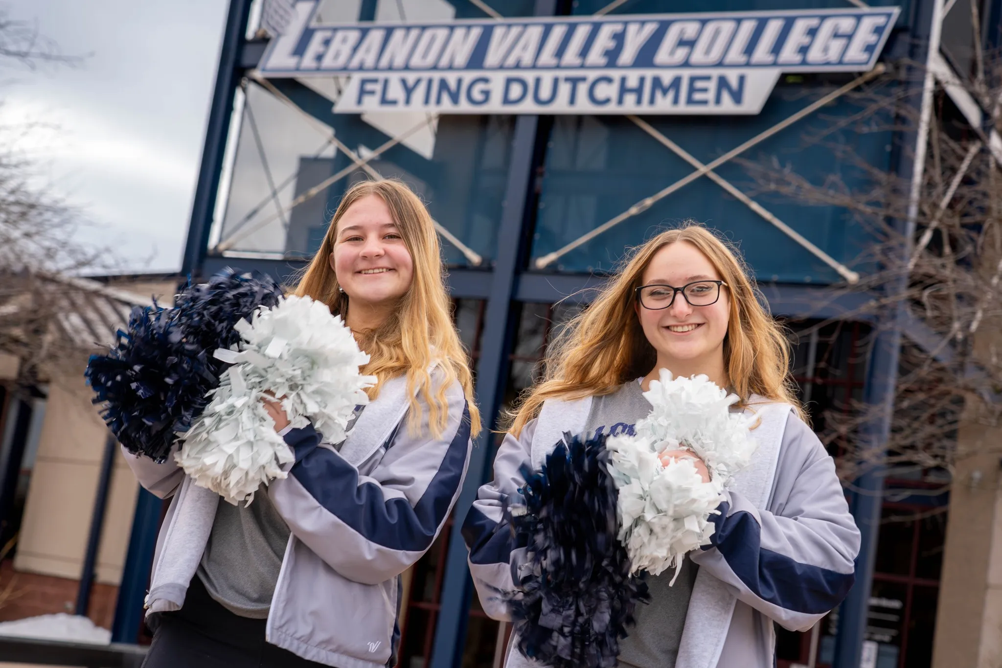 Students pose with pom poms in front of LVC sports center