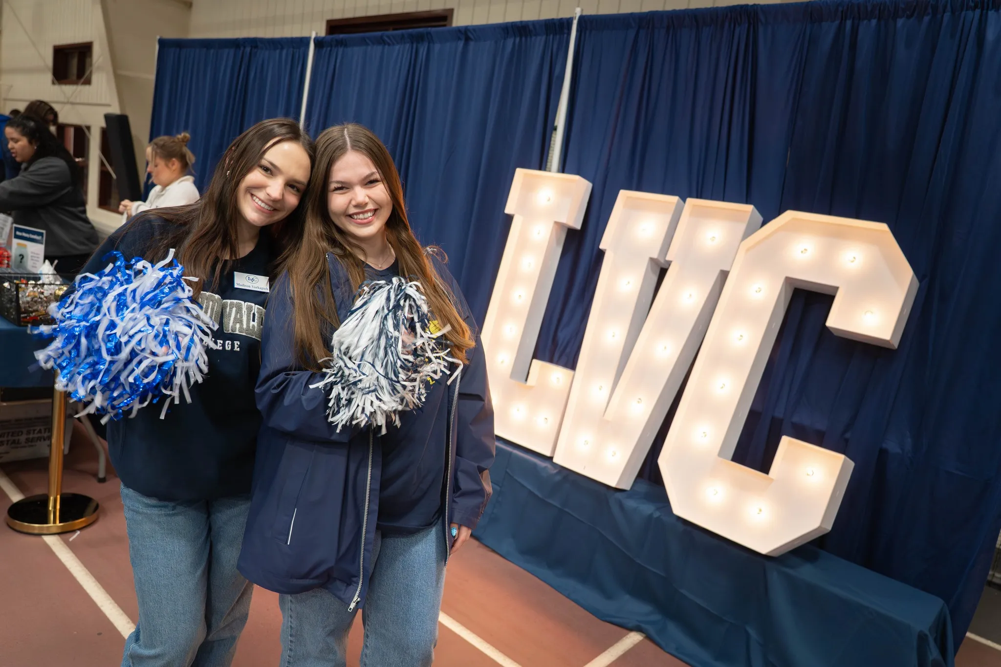 Students pose with light up LVC sign