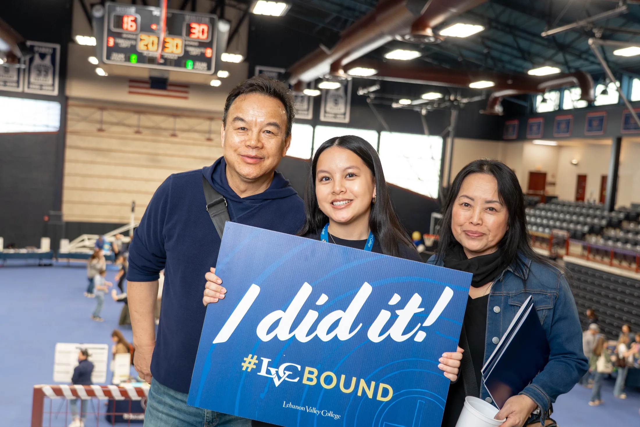Newly enrolled student holds "I did it!" sign with family at LVC Live admitted student event