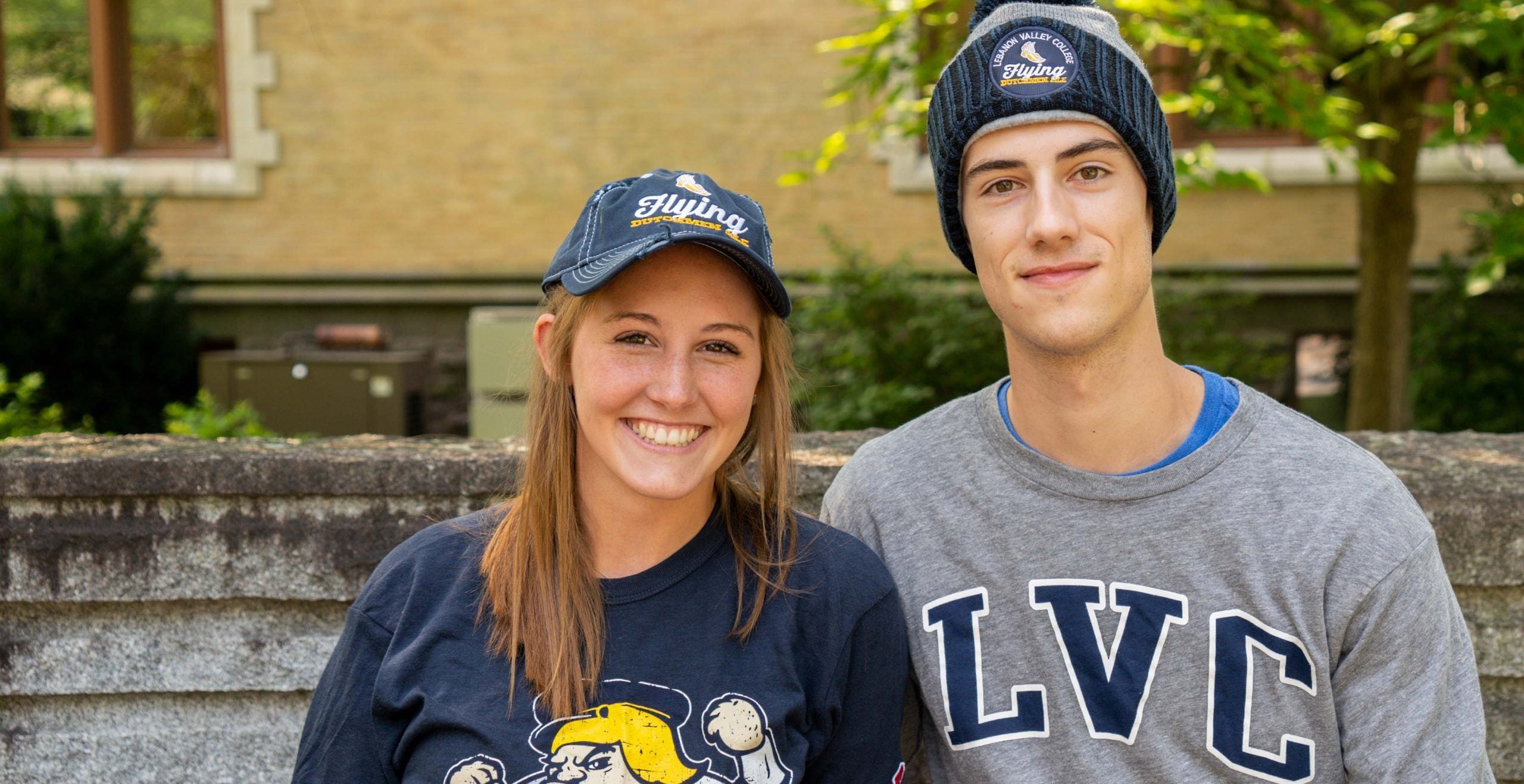 Two LVC alumni smiling in LVC hats and shirts.