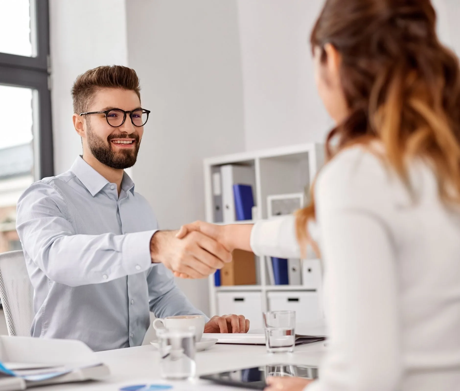 Man and woman shake hands in office setting