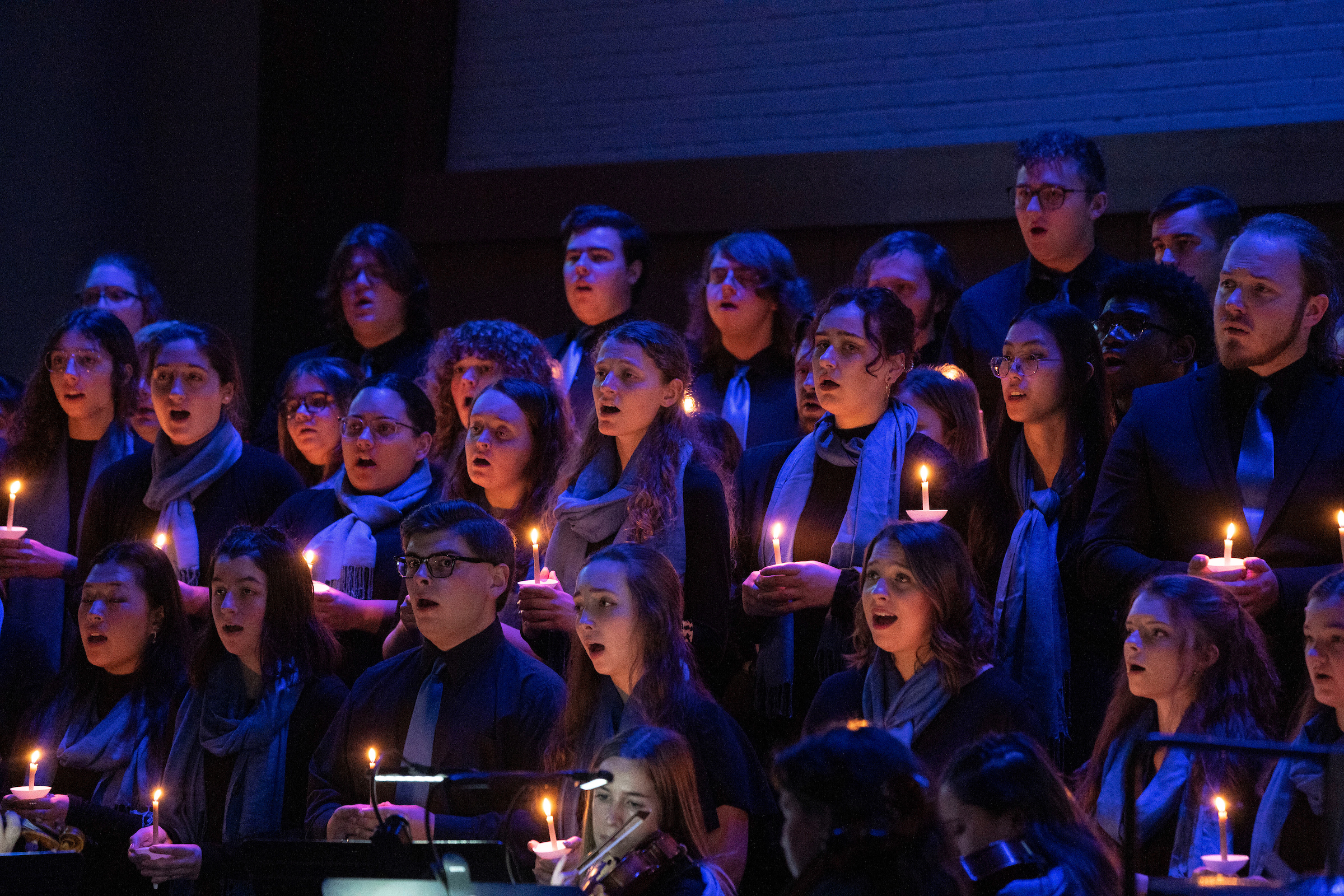 Students sing by candelight