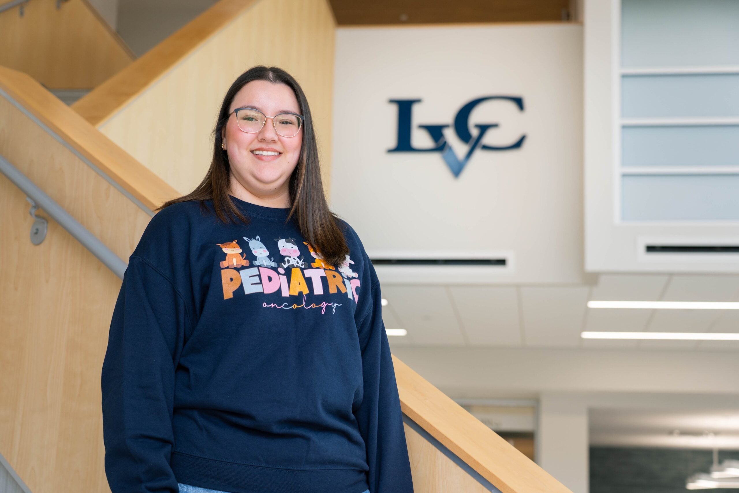 Angeles Espinoza poses on staircase in PAM Health School of Nursing at Lebanon Valley College