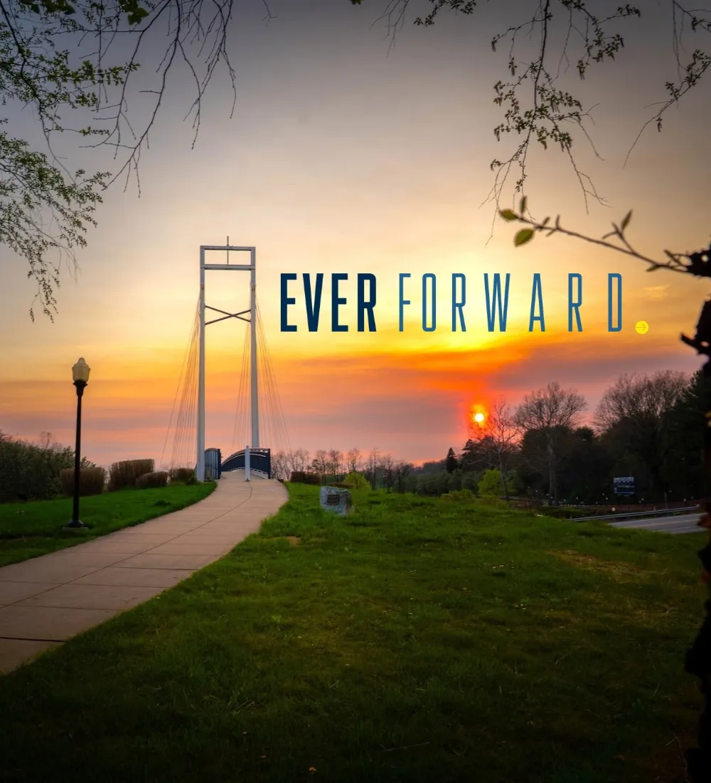LVC campus bridge at sunset with Ever Forward campaign logo