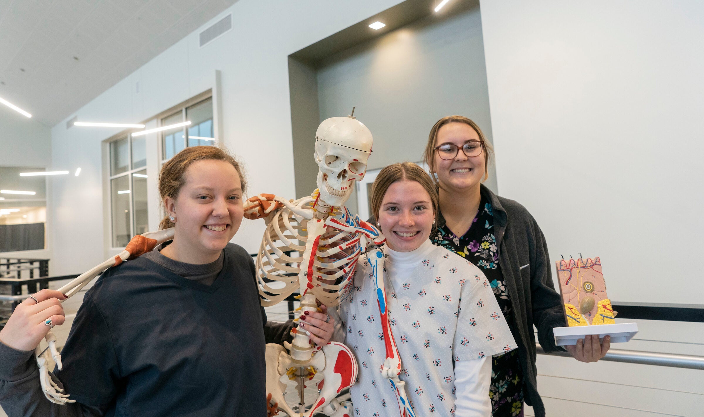 Students pose with skeleton in lab