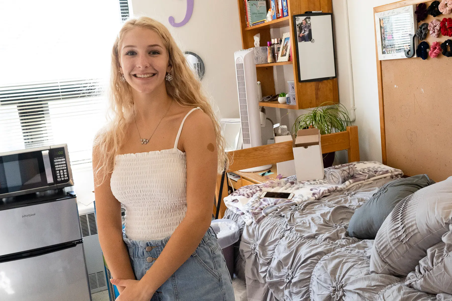 Student smiling in dorm room.