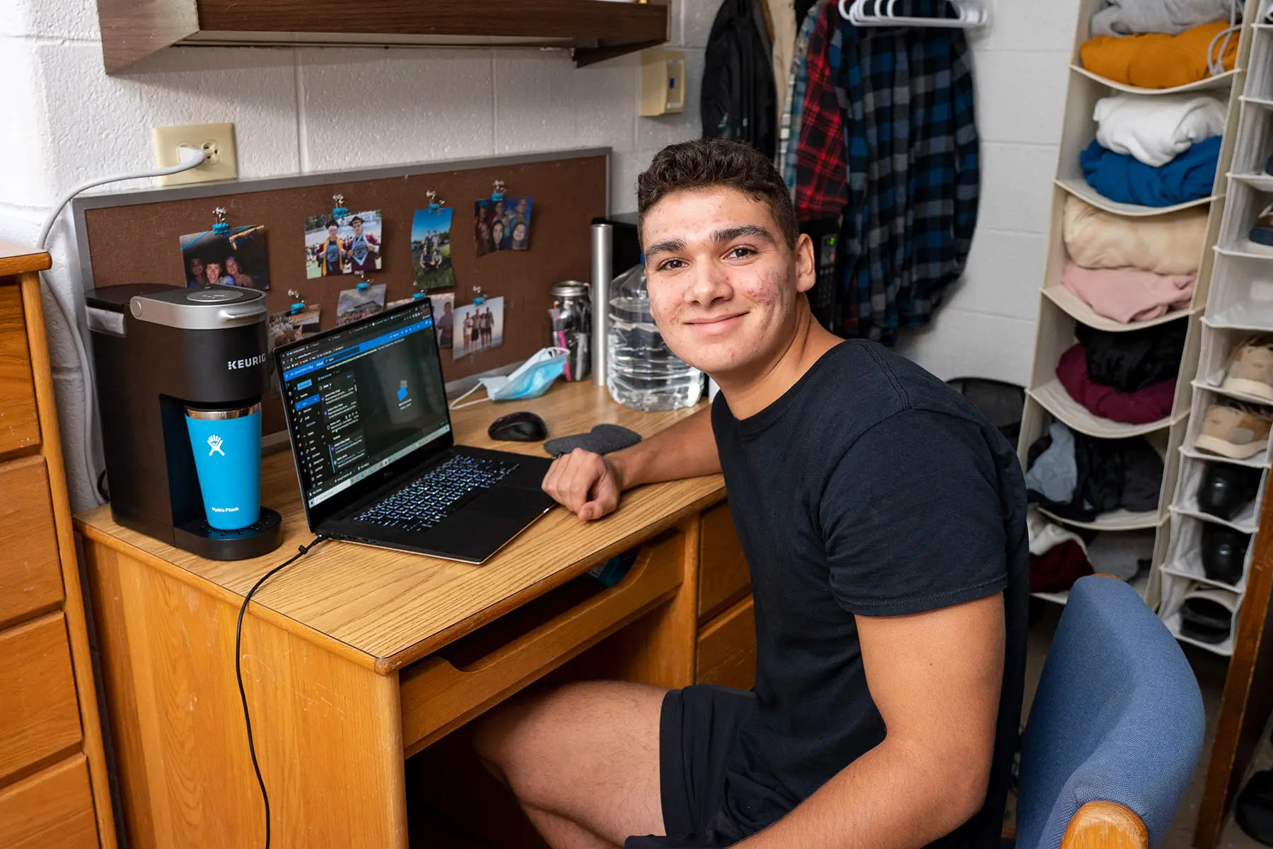 Student sits at dorm desk.