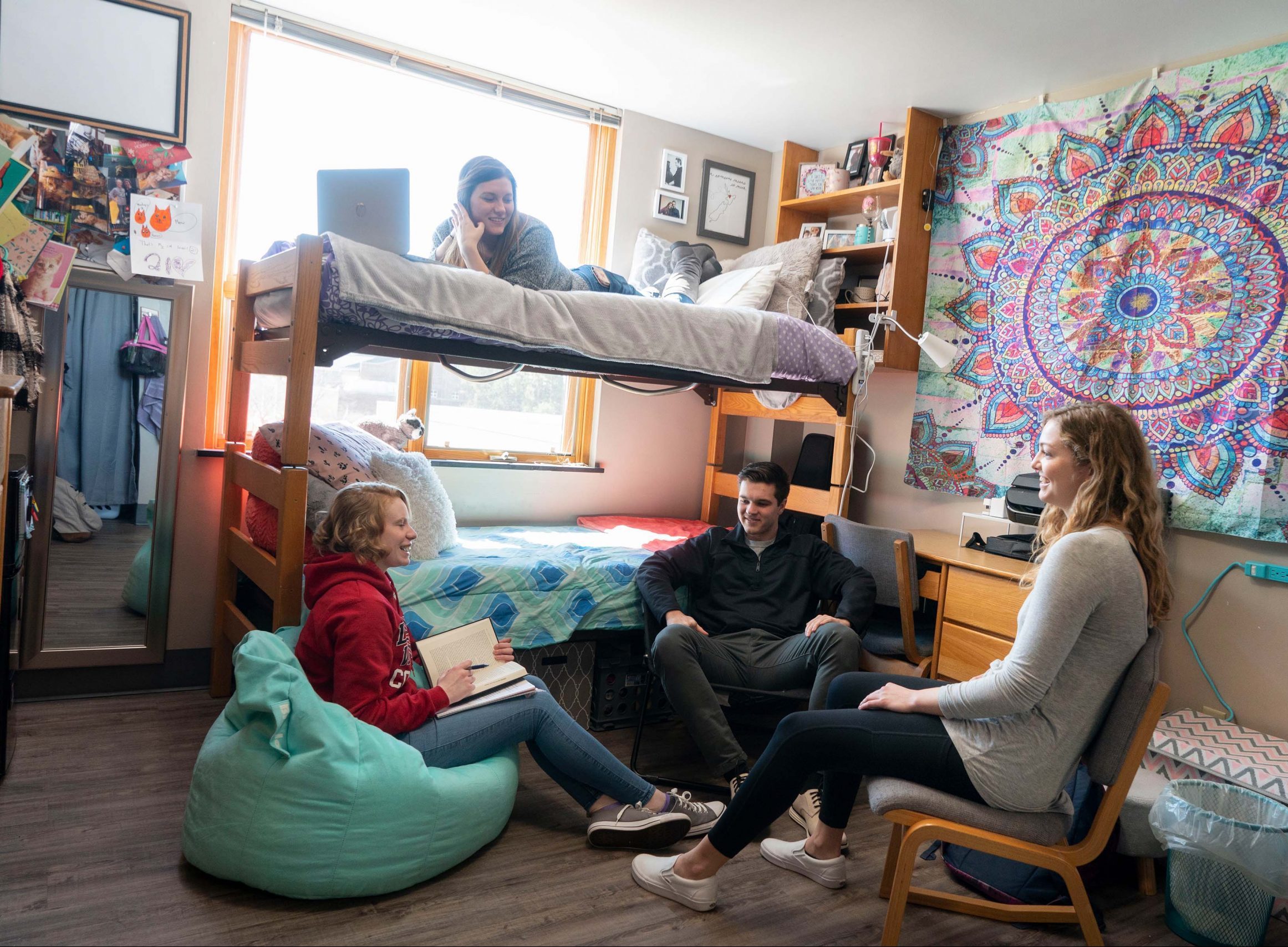 Students chatting in dorm room.