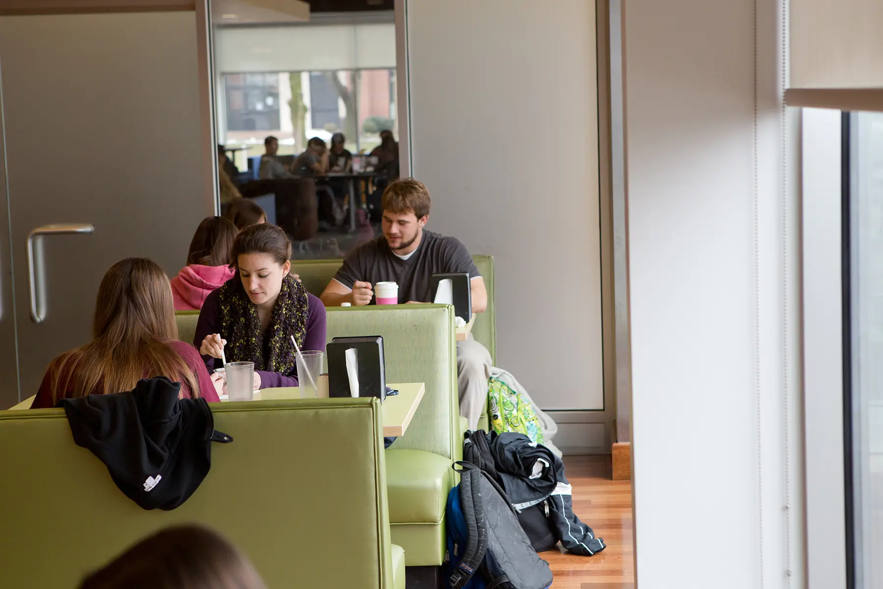 Students sit in booths eating and studying