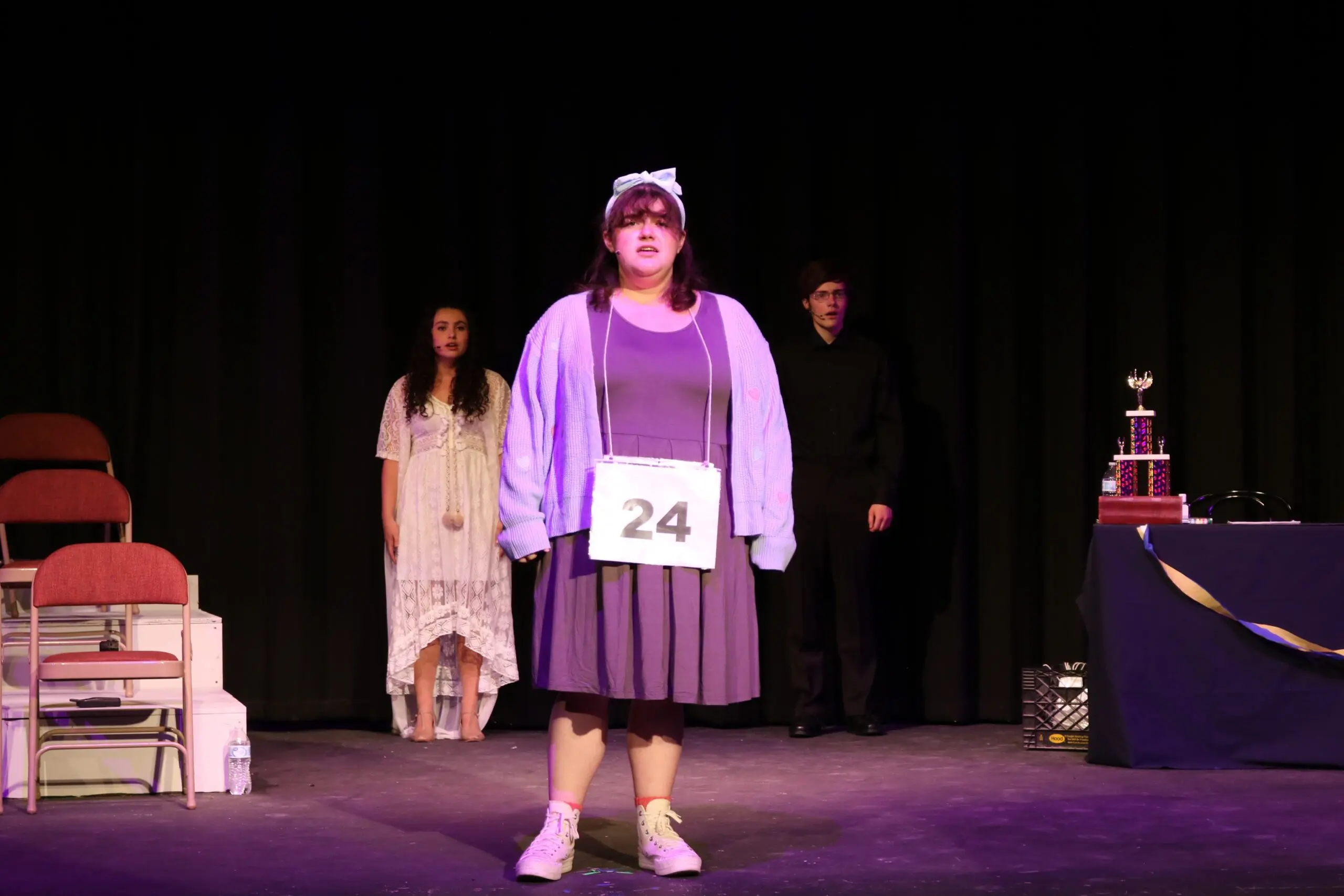 Student stands on stage during theater production