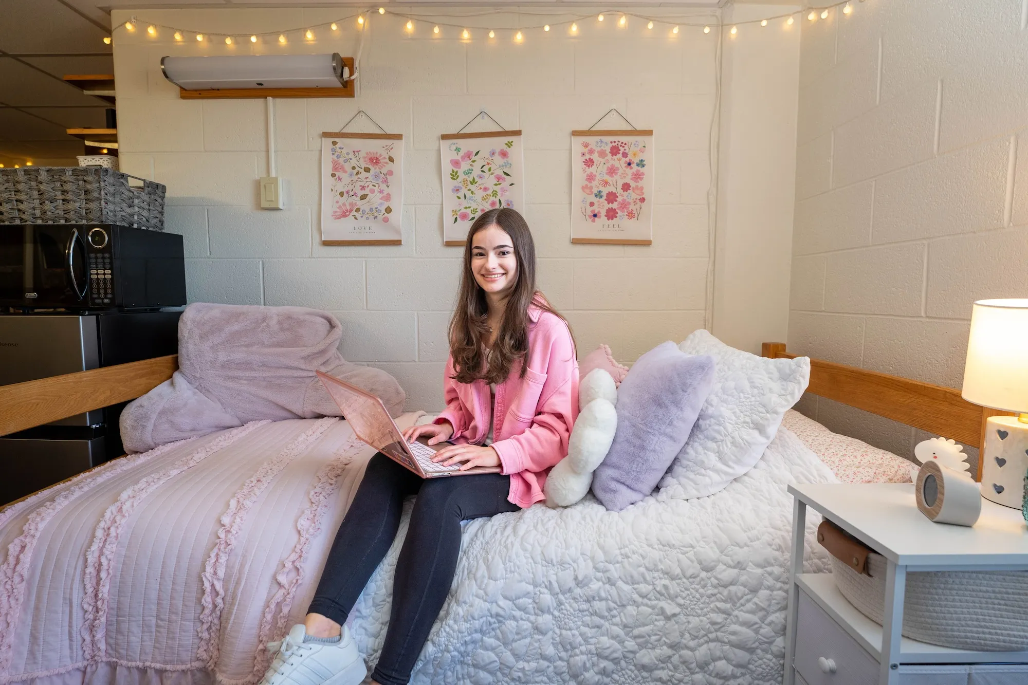 Student sits on bed in dorm room in Funkhouser Hall