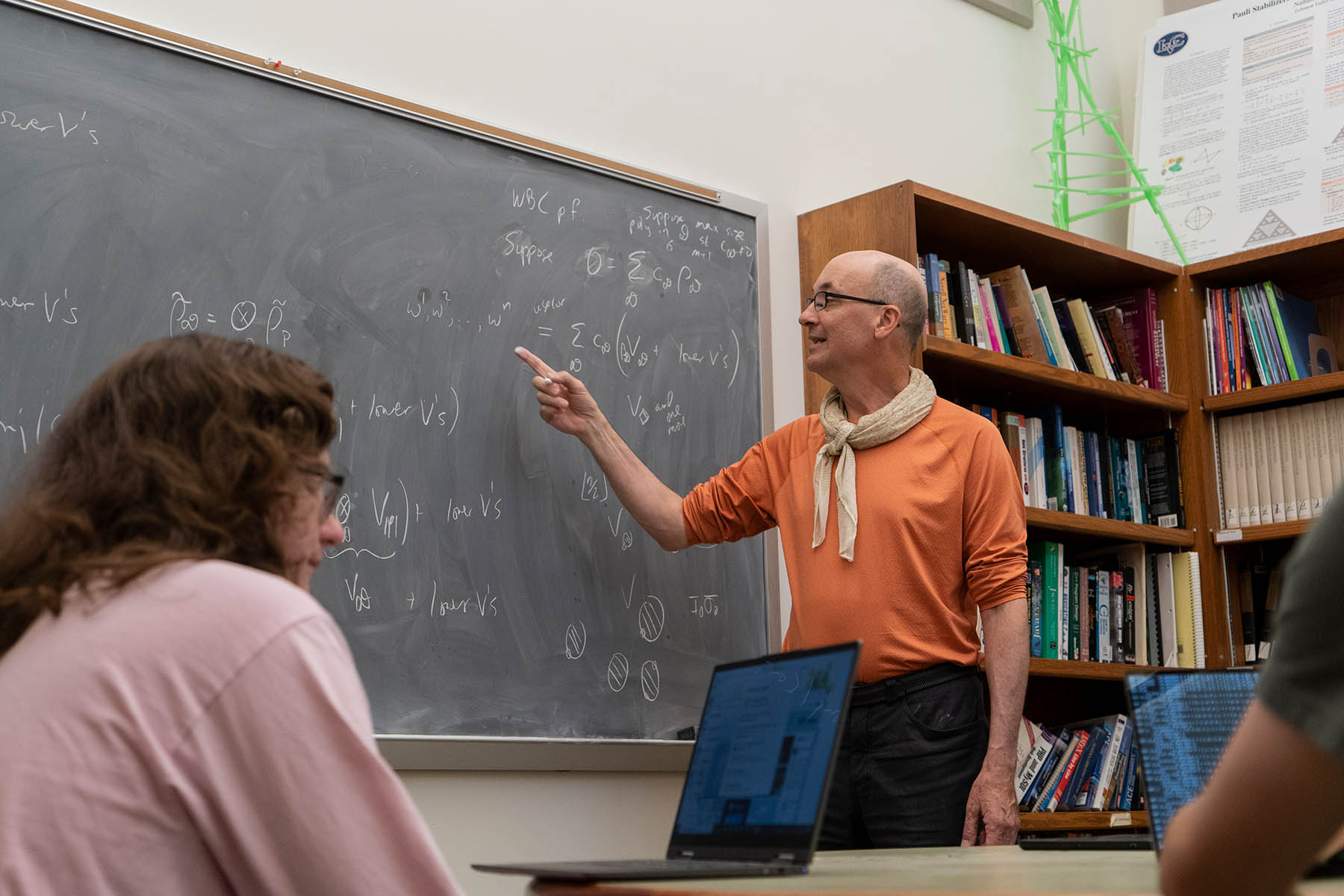 Professor pointing to an equation on a chalkboard.