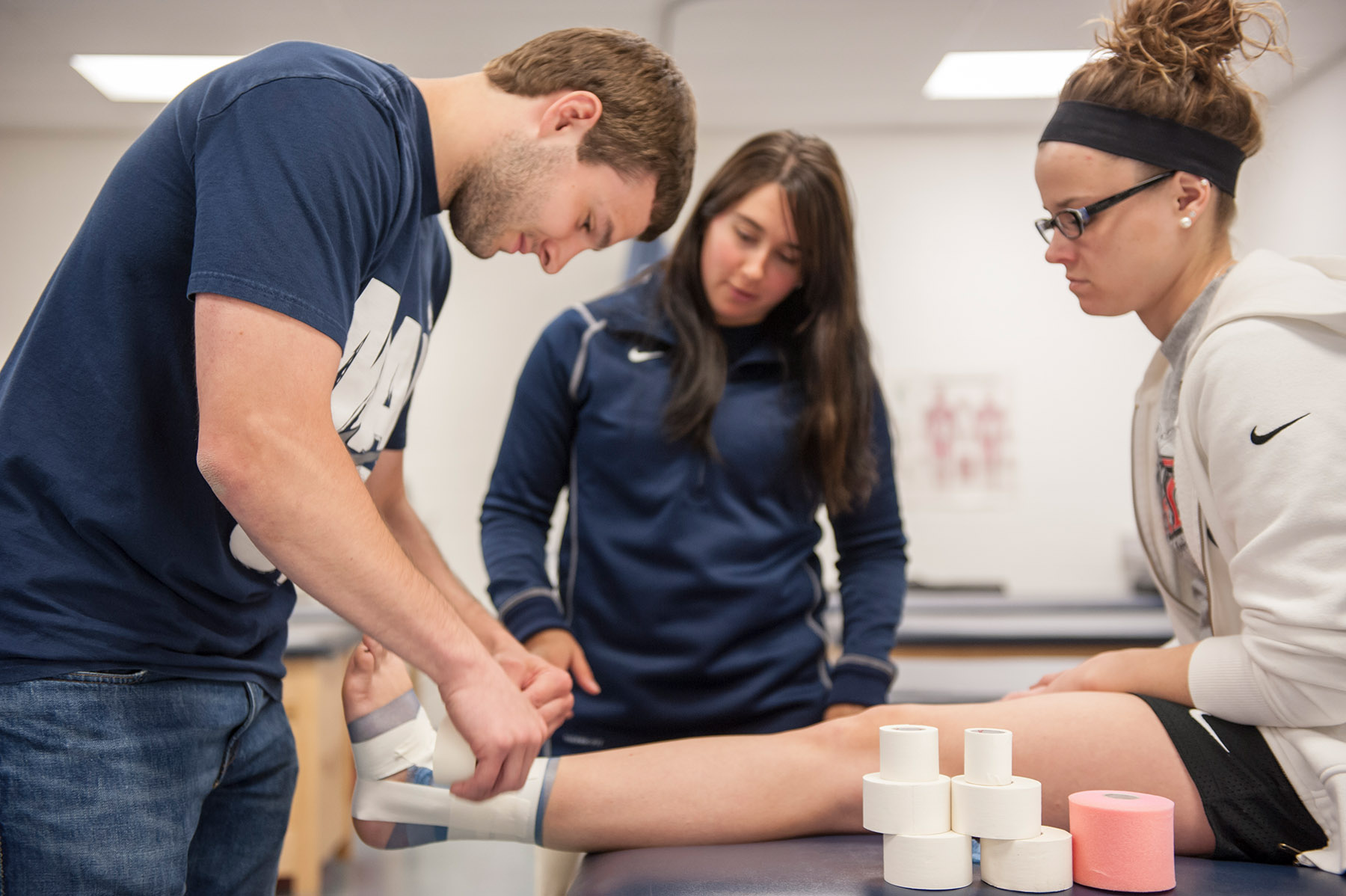 Athletic training student working with athlete in lab