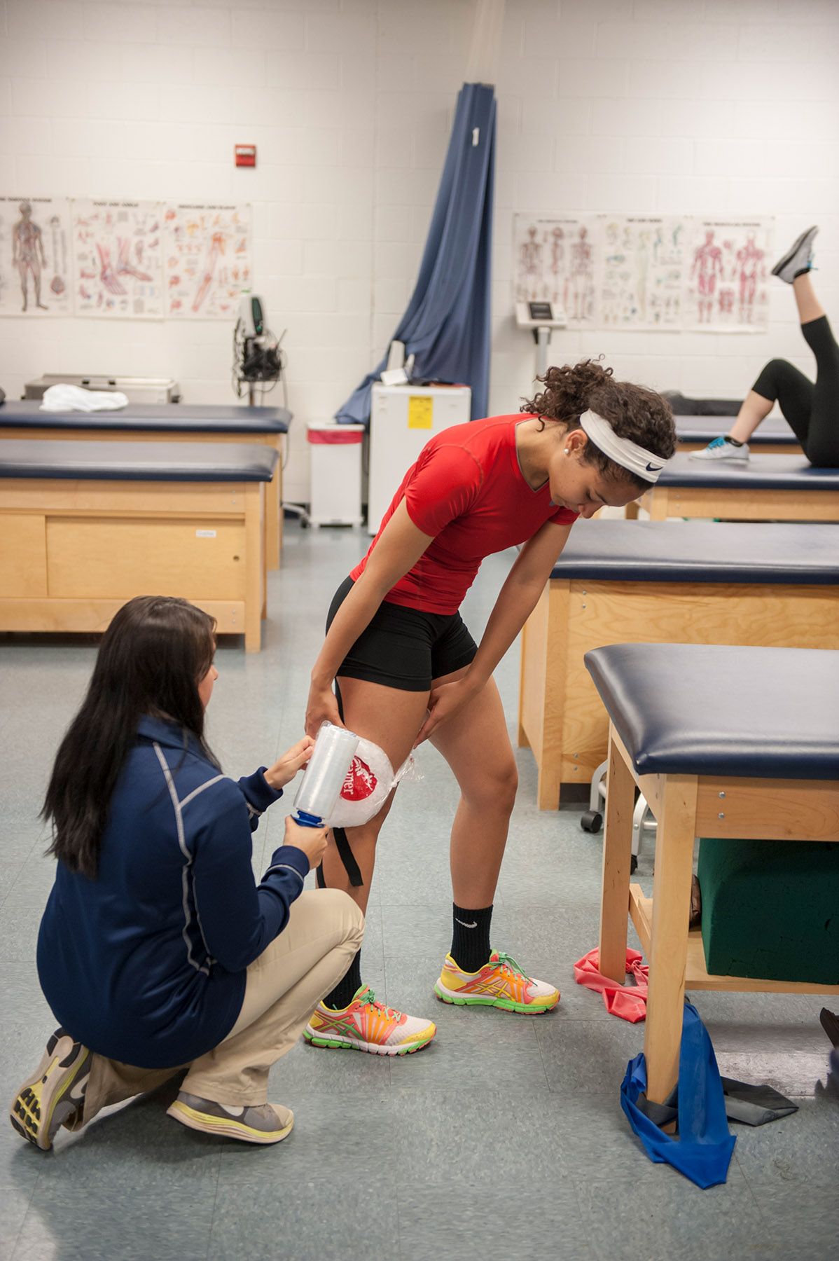 Student training student working with athlete in lab
