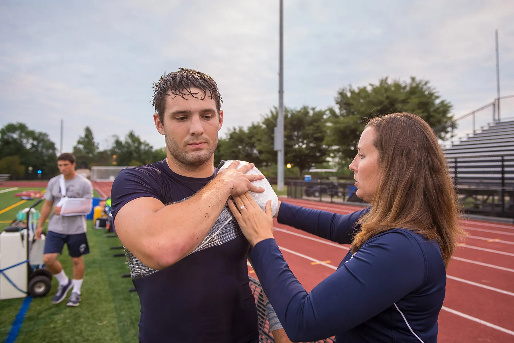 Athletic training students working with football player