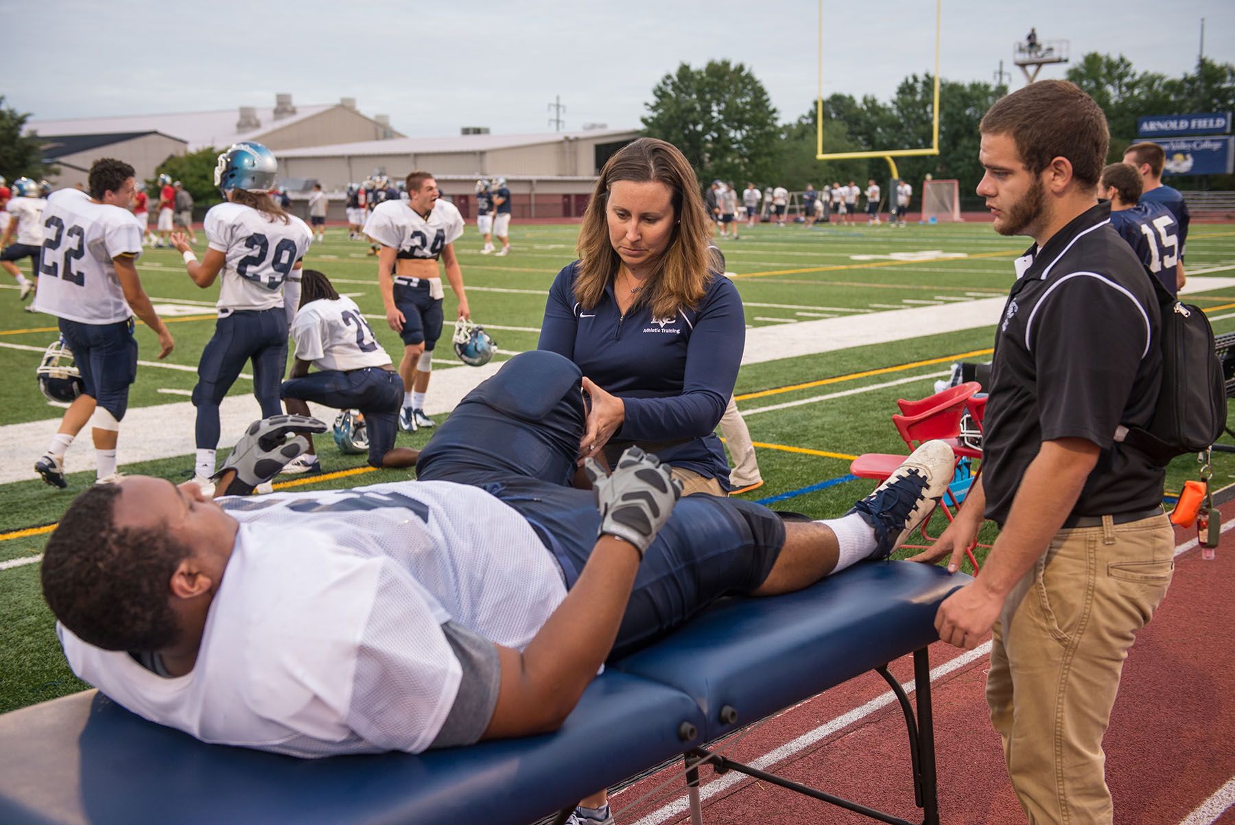 Athletic training students working with football player