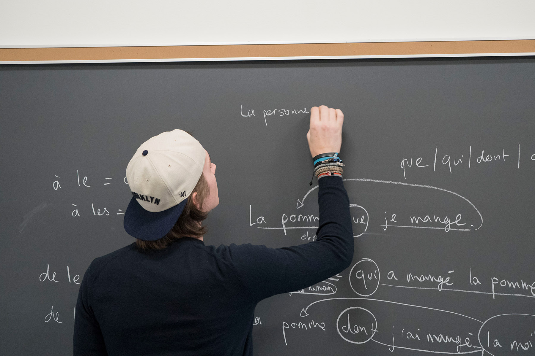 Student diagramming french sentences on chalkboard