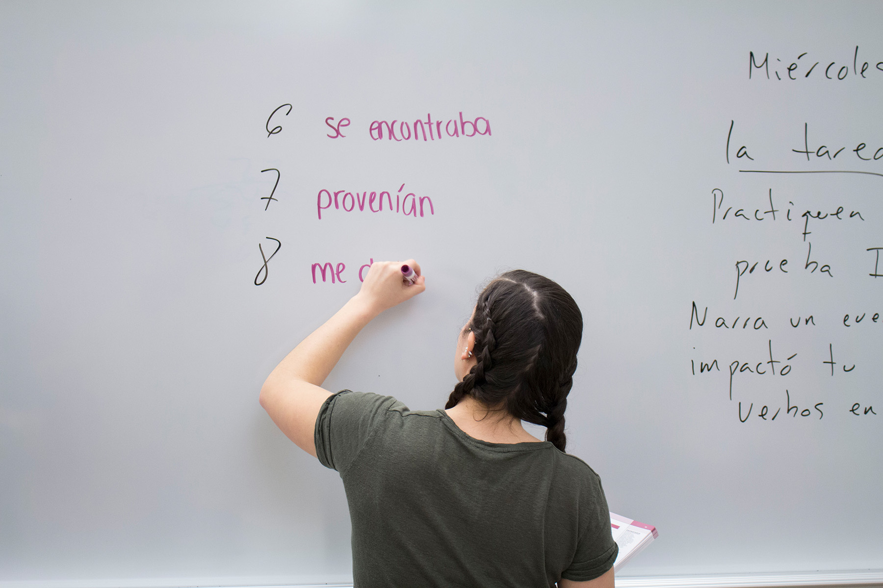 Student writing spanish words on whiteboard