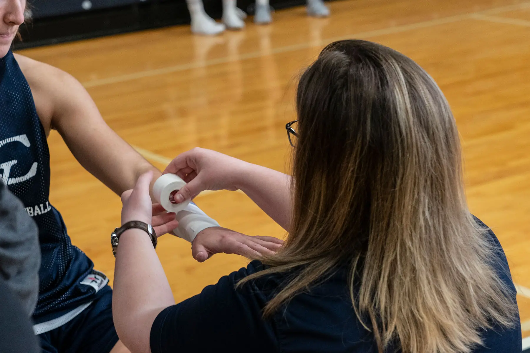 Student training student working with athlete in gym