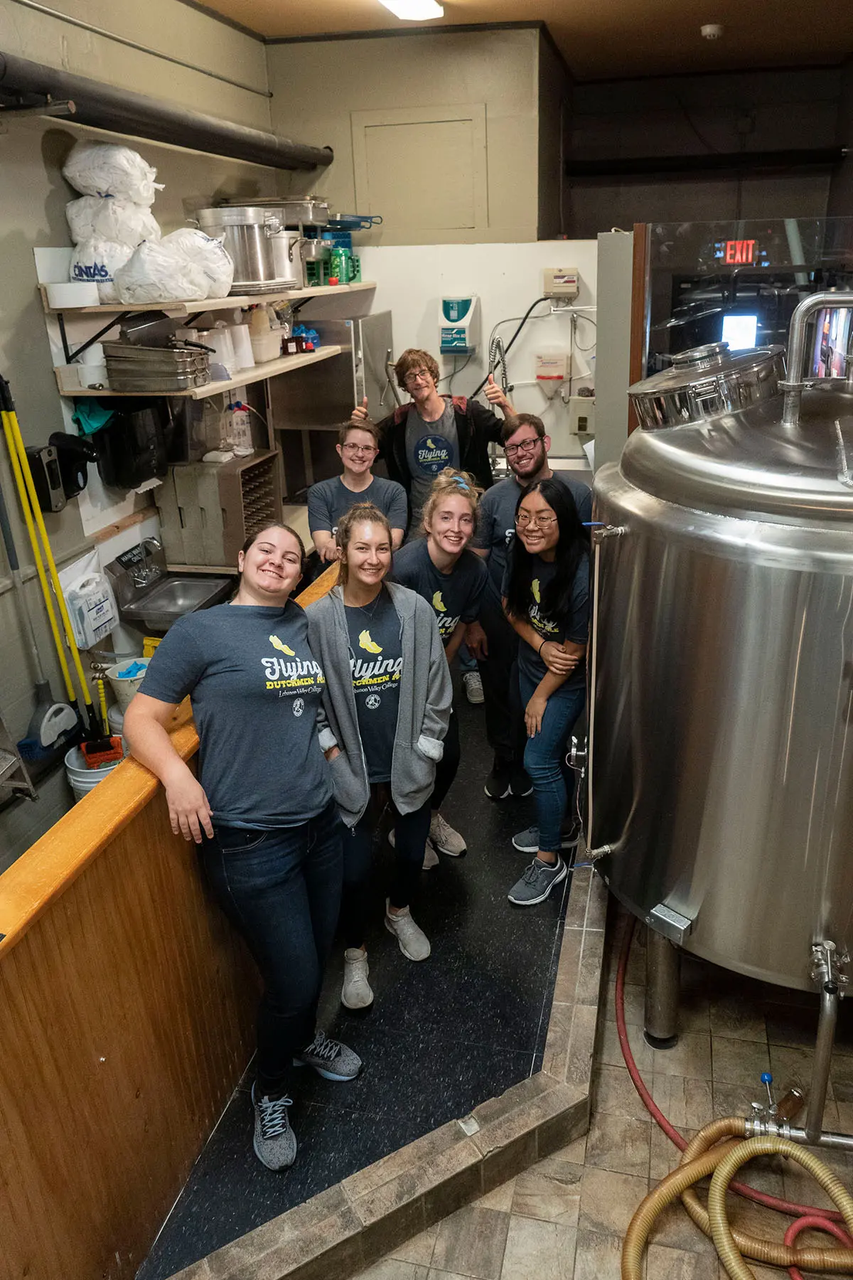 Beer Crew studnets posing with beer brewing equipment