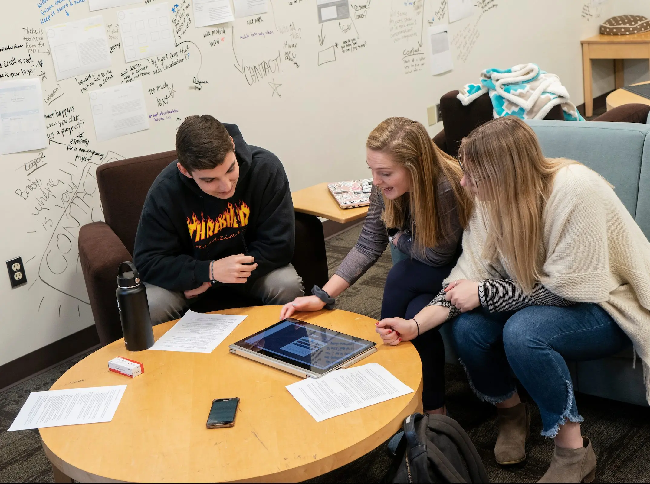 Digital Communication students critique capstone projects around table