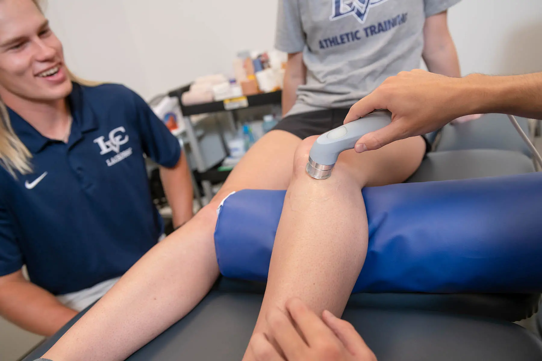 Student training student working with athlete in lab