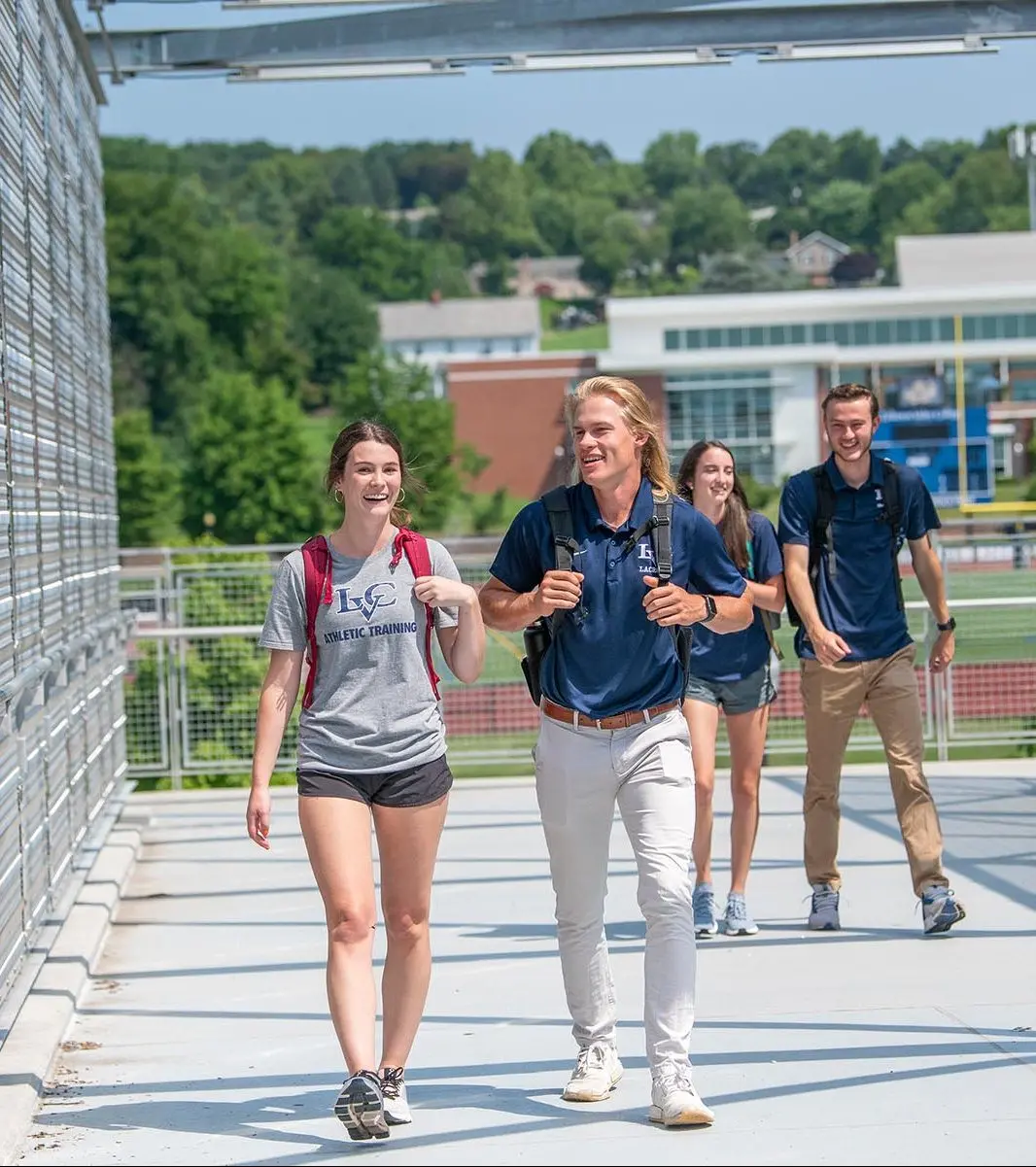 Female student in a gray LVC t shirt walks with male college student in blue polo shirt