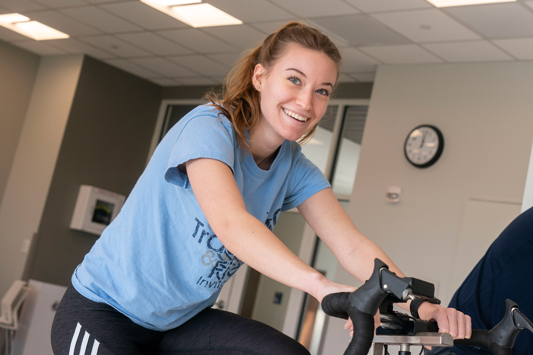 Student smiling on. exercise bike