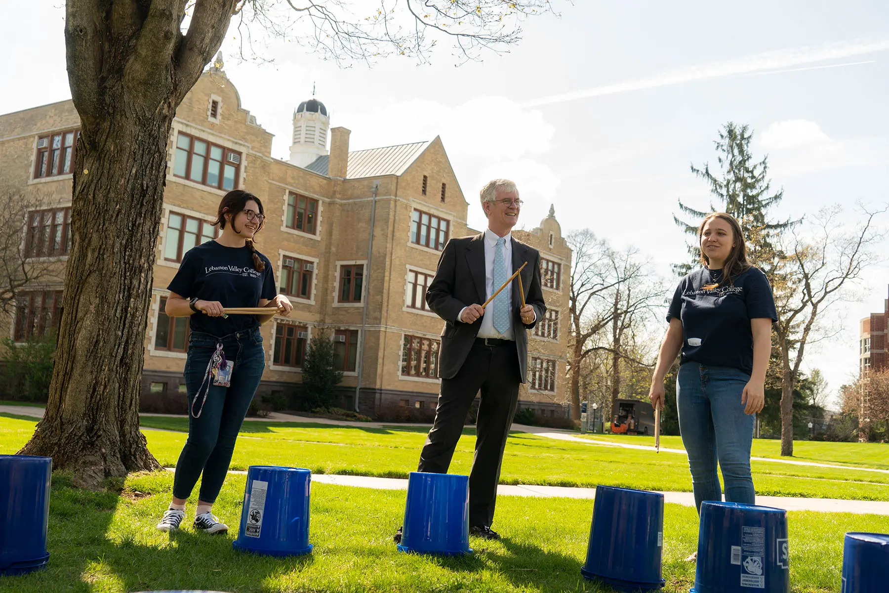 President and student son campus playing makeshift drums