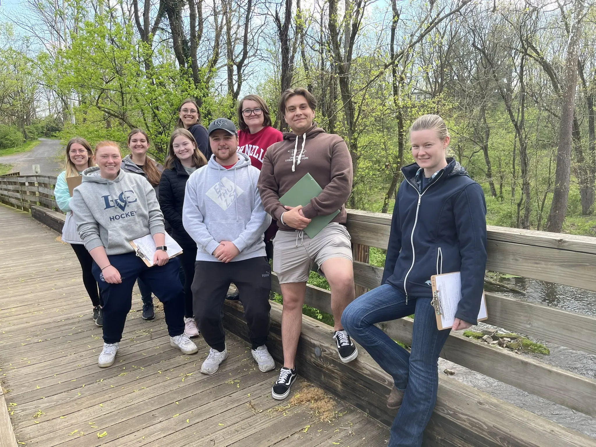 Students in plant diversity take notes in park.