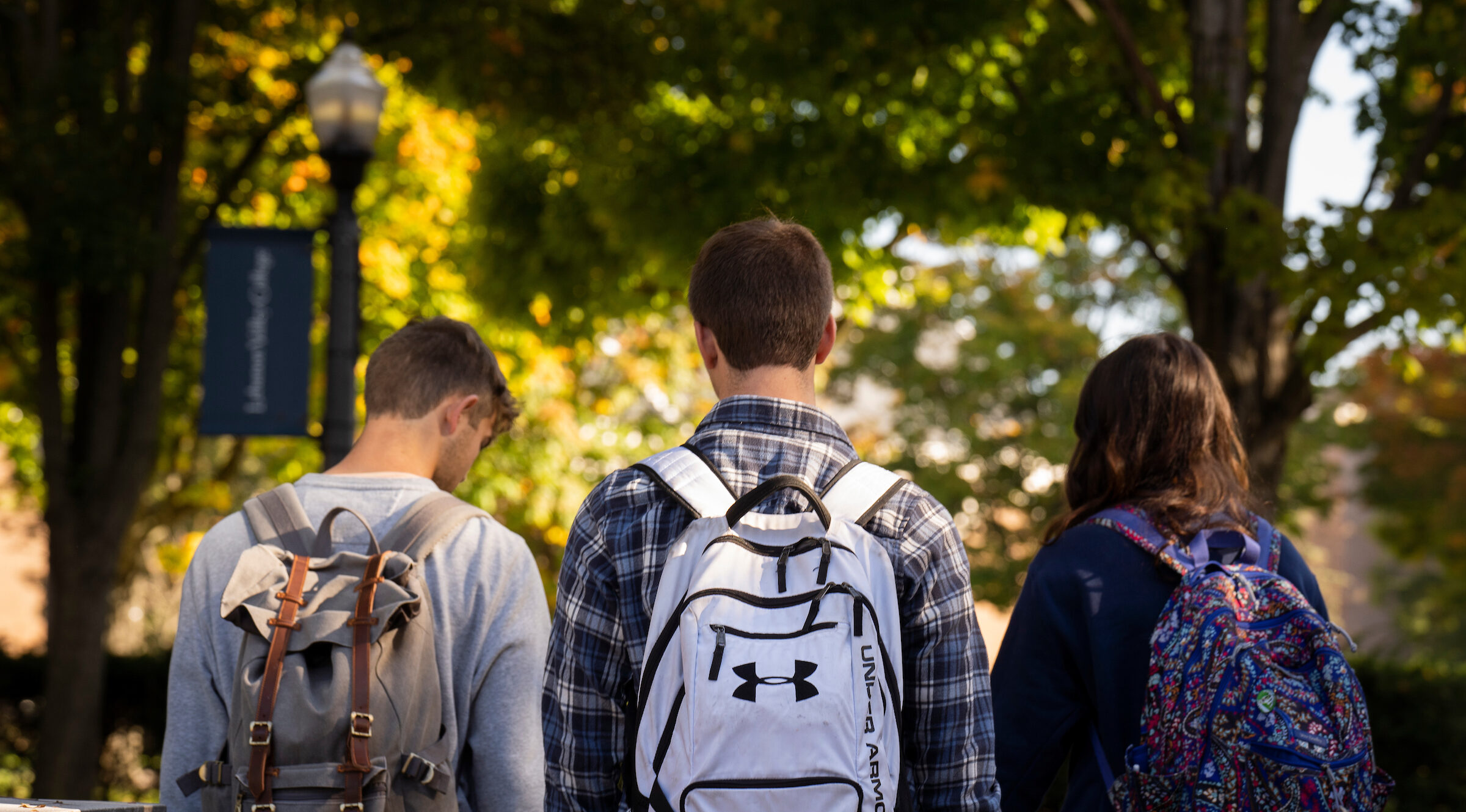 Students walk on campus with backpacks