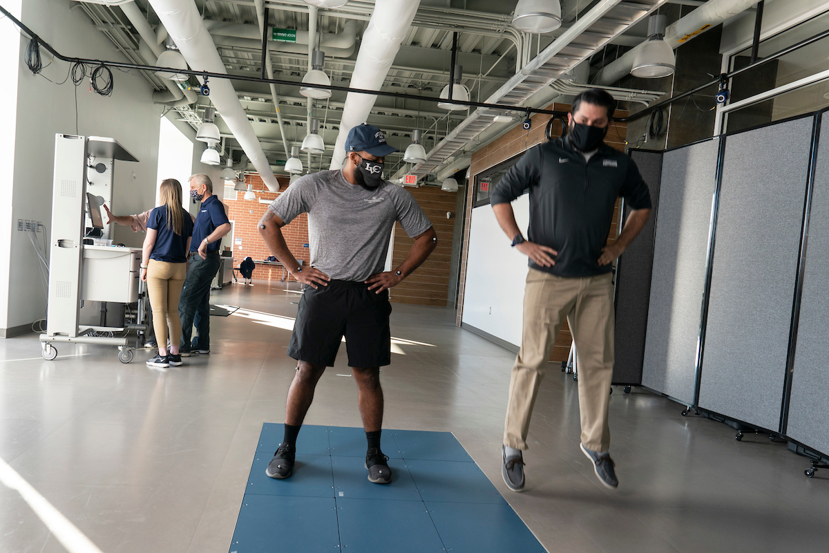 Exercise science student and instructor do jumping activity in Human Performance Lab
