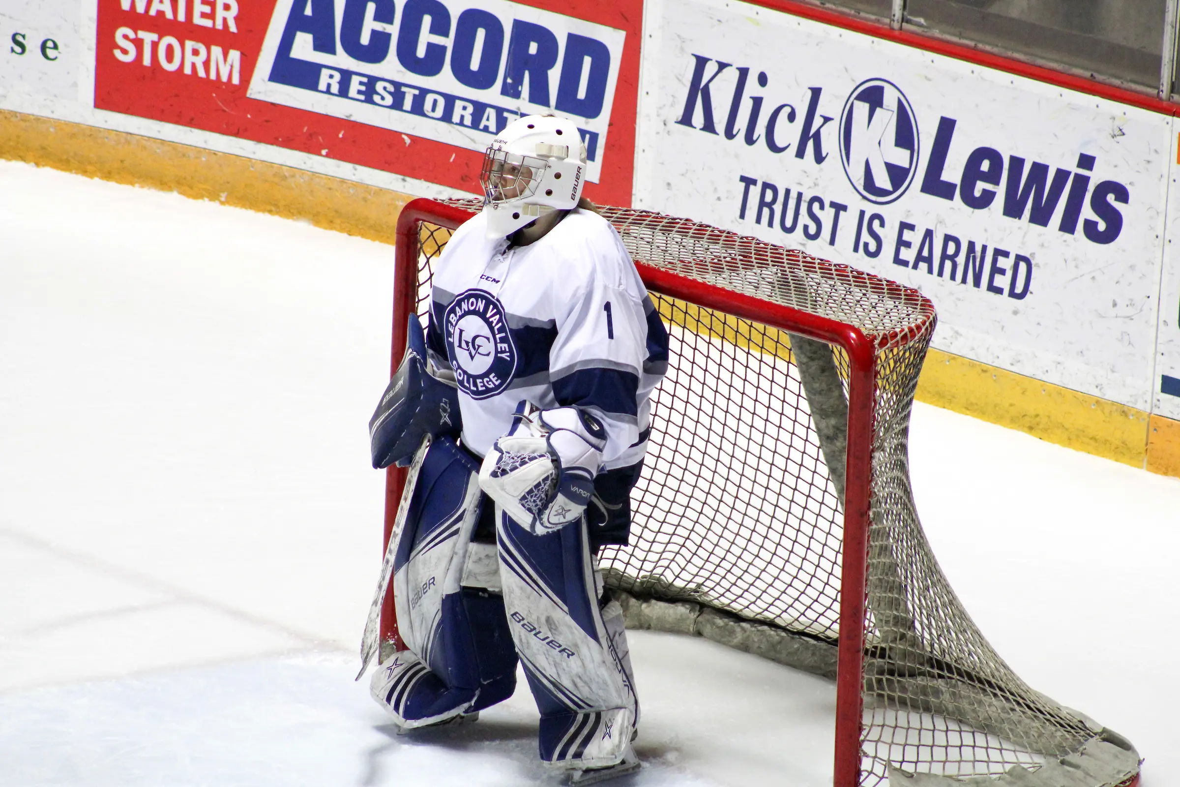 women's ice hockey player stands in goal