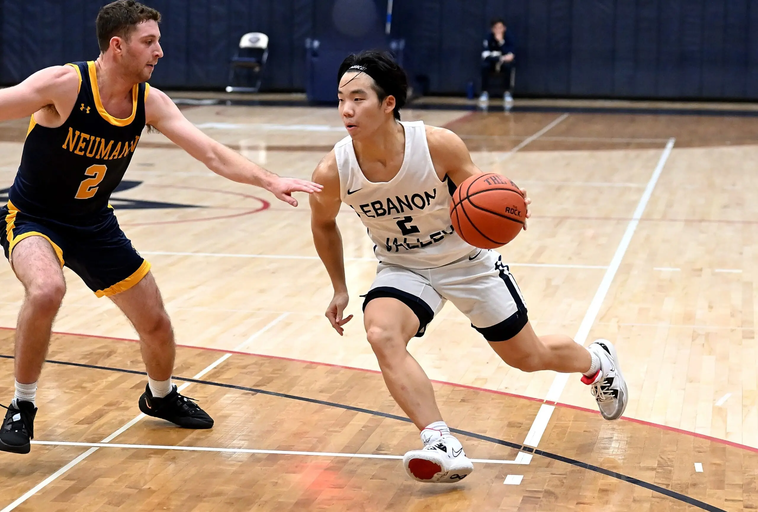 LVC men's basketball player dribbles ball on court