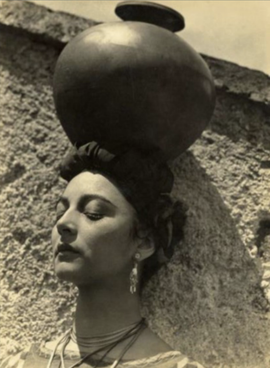 Photo of woman standing and balancing pot on her head