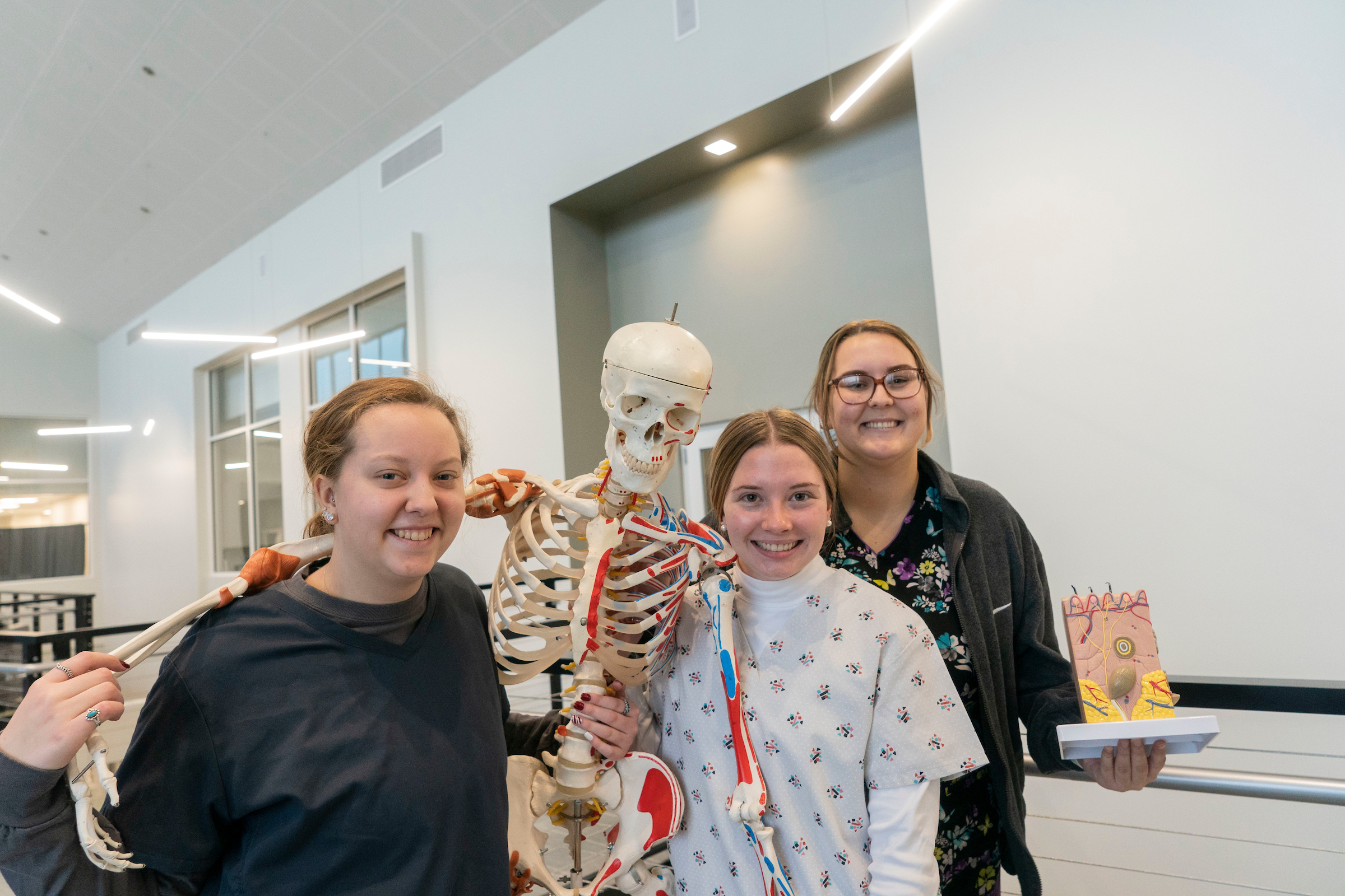Students pose with skeleton in lab