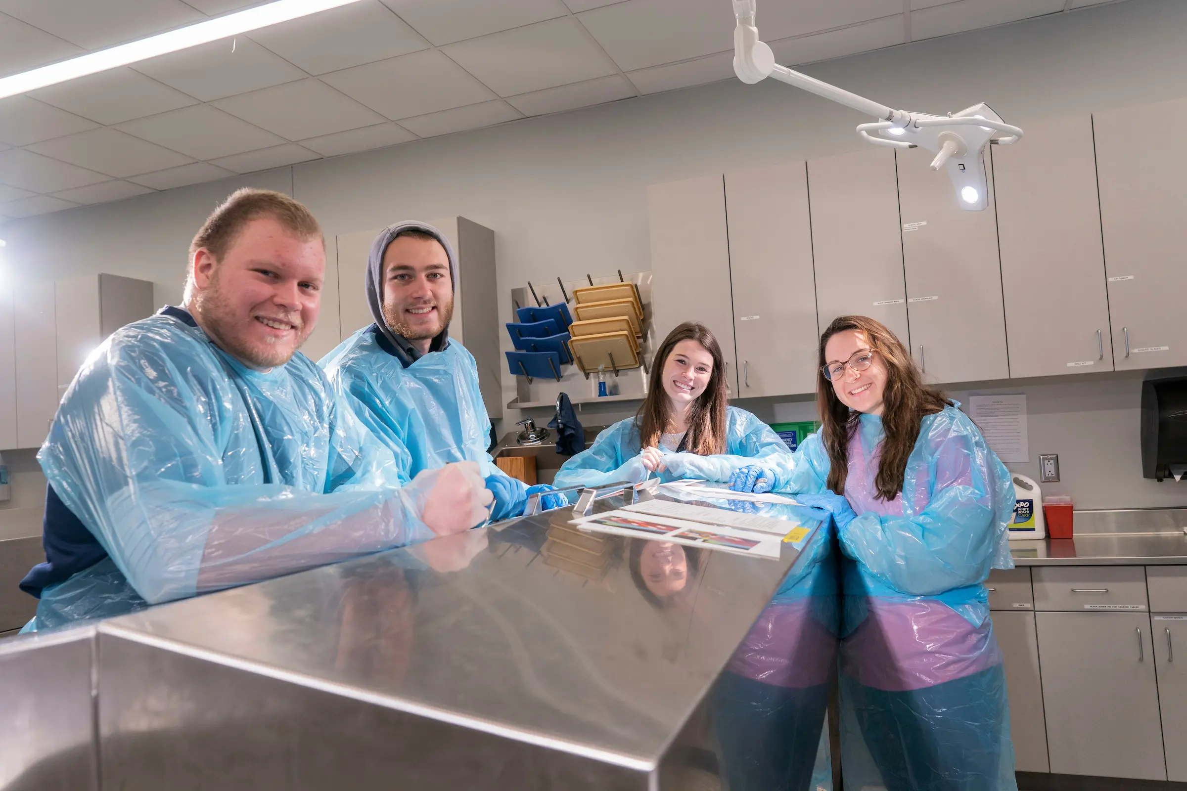 Athletic training students stand around table in cadaver lab