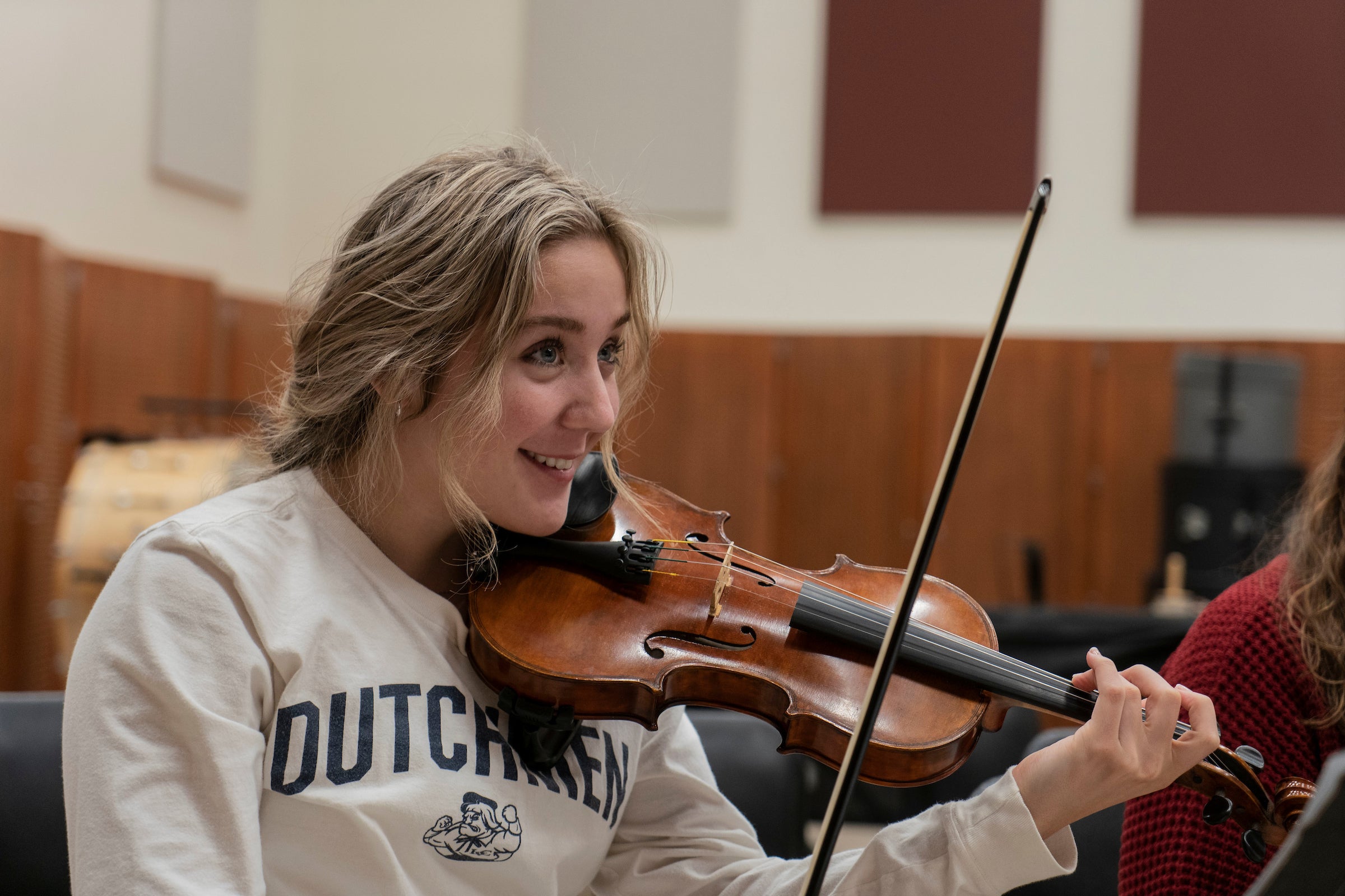 Student holds violin during music class