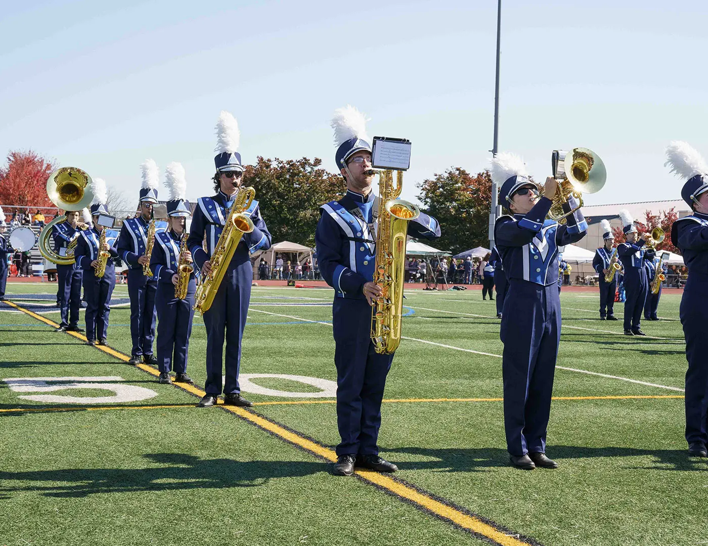 Marching band members play on field