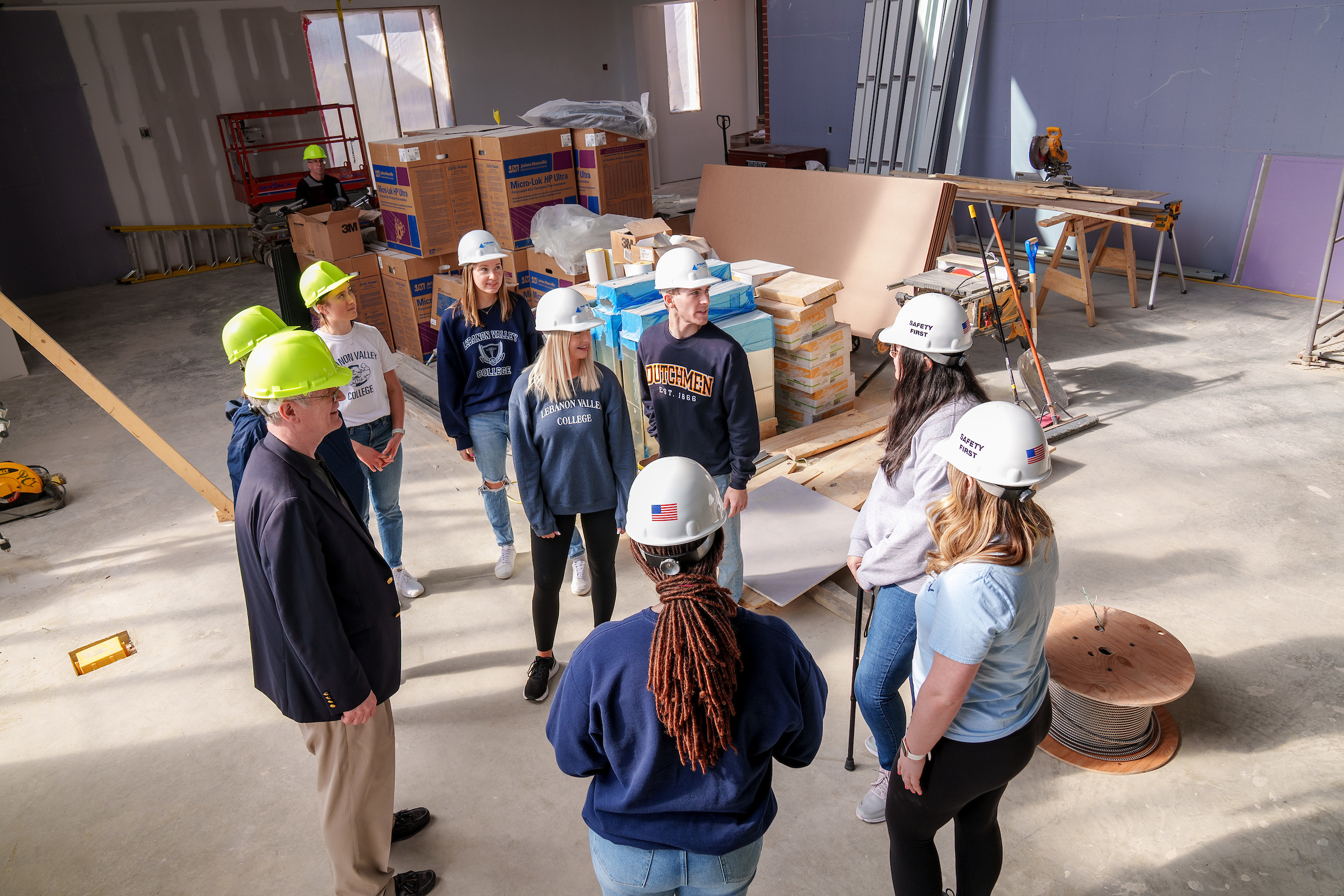 Nursing students pose in hard hats in new building